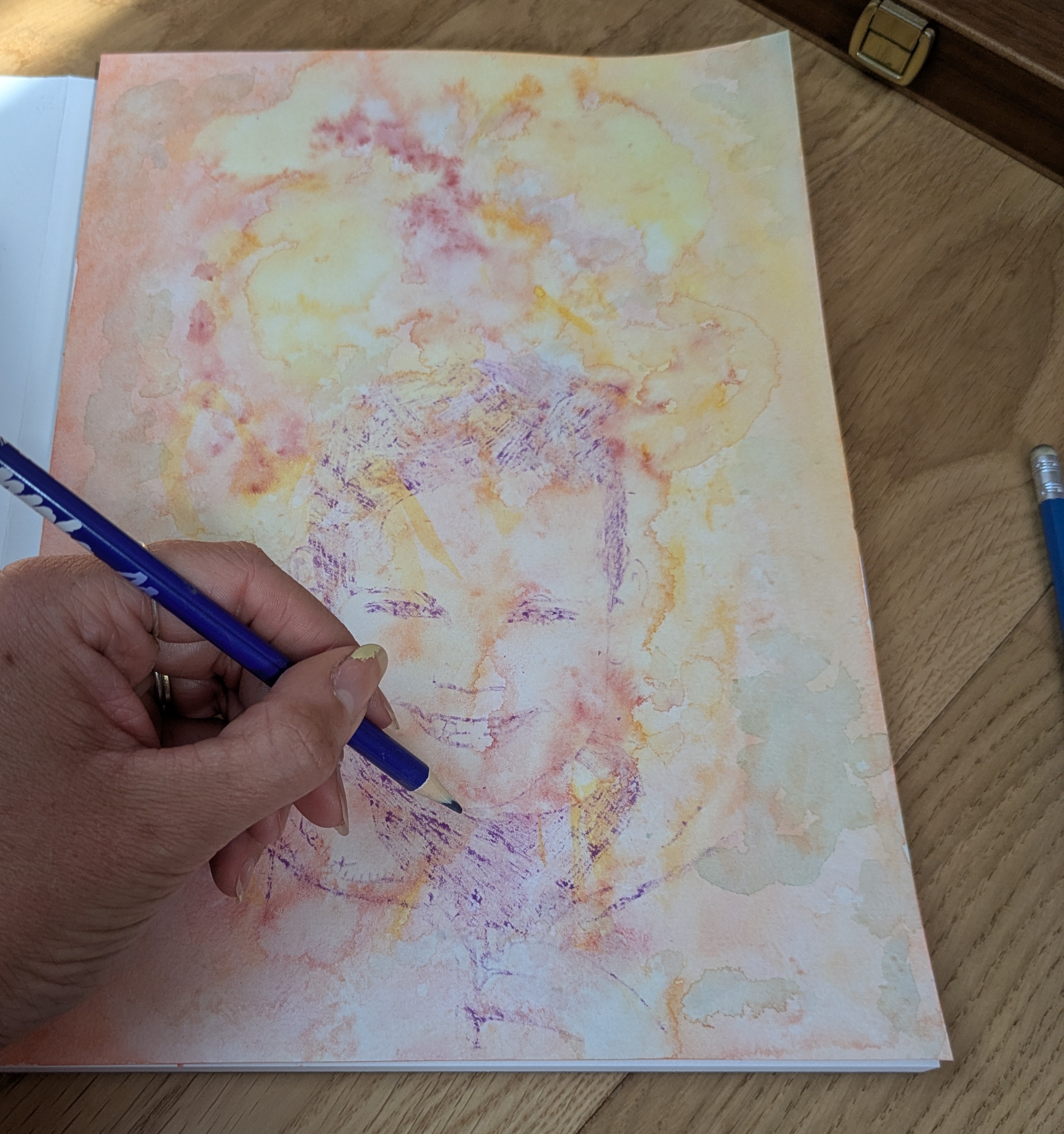 Transfert du portrait sur un fond aquarellé pendant l’atelier Couleurs de Soi